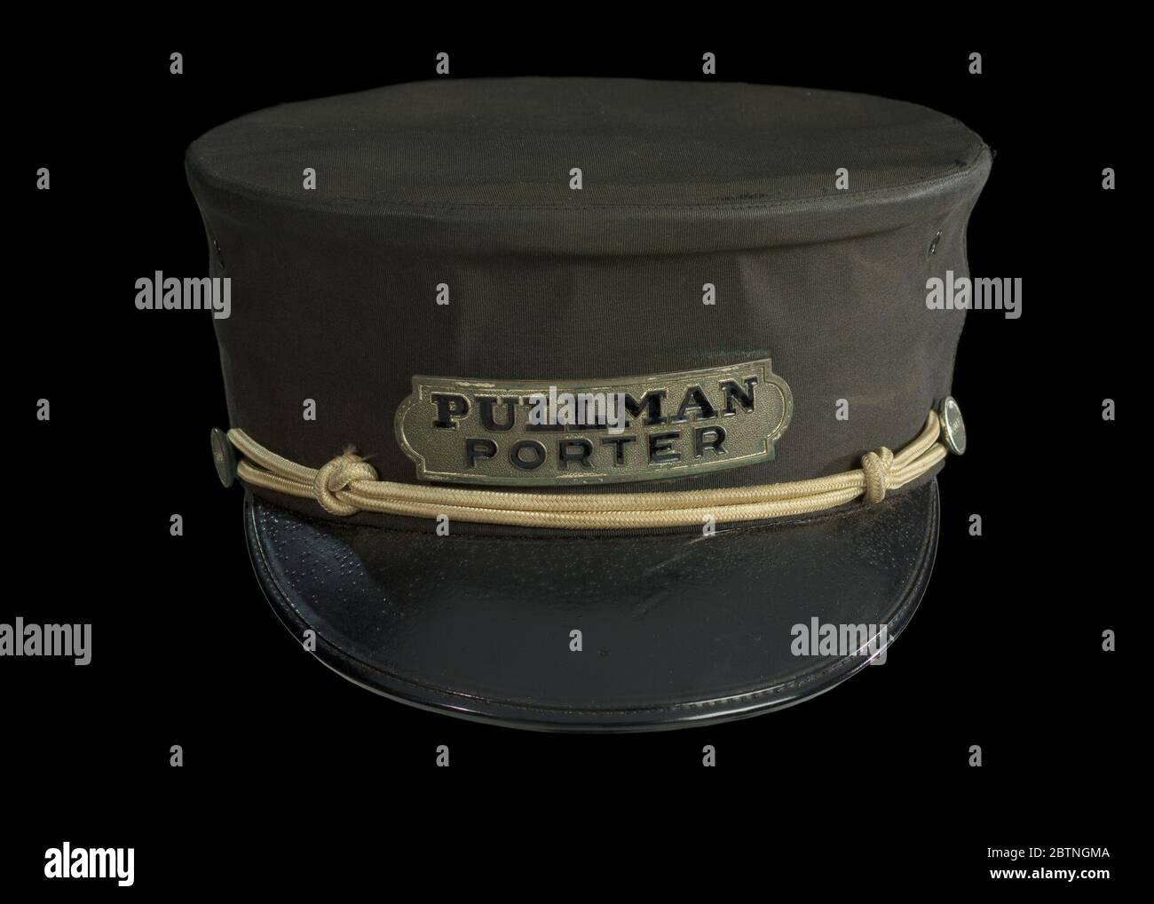 Uniform cap for a Pullman Porter. Navy blue Pullman Porter's cap with brass buttons and rope detail and metal Pullman Porter tag attached to the front above the bill of the cap. Stock Photo