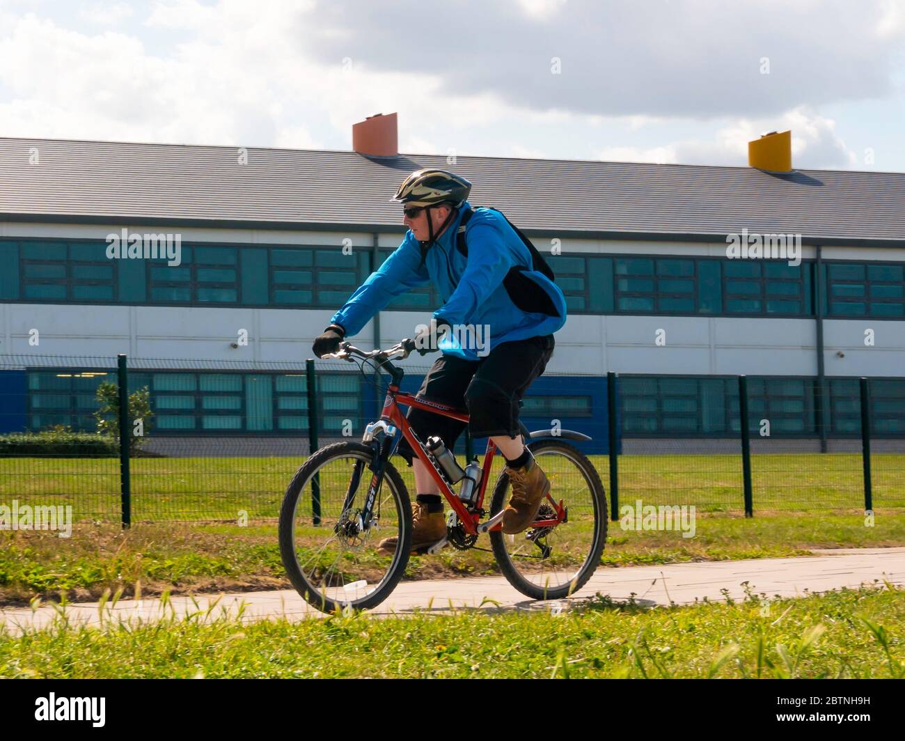 A middle aged man in a blue jacket riding an off road sports bicycle on a cycle track in North Yorkshire Stock Photo