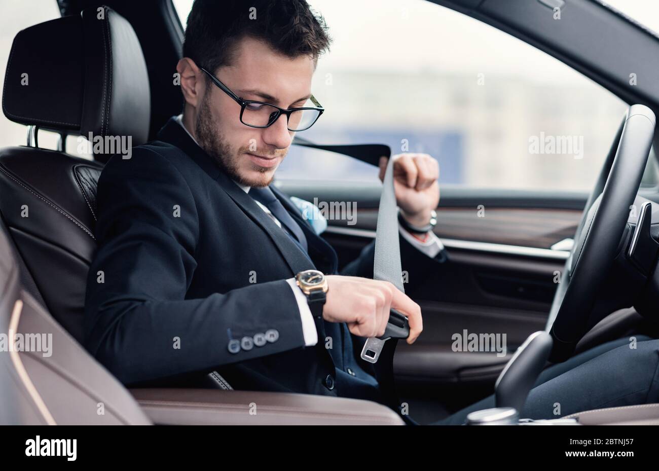 Business Man Putting On Seat Belt Sitting In Luxury Car Stock Photo Alamy