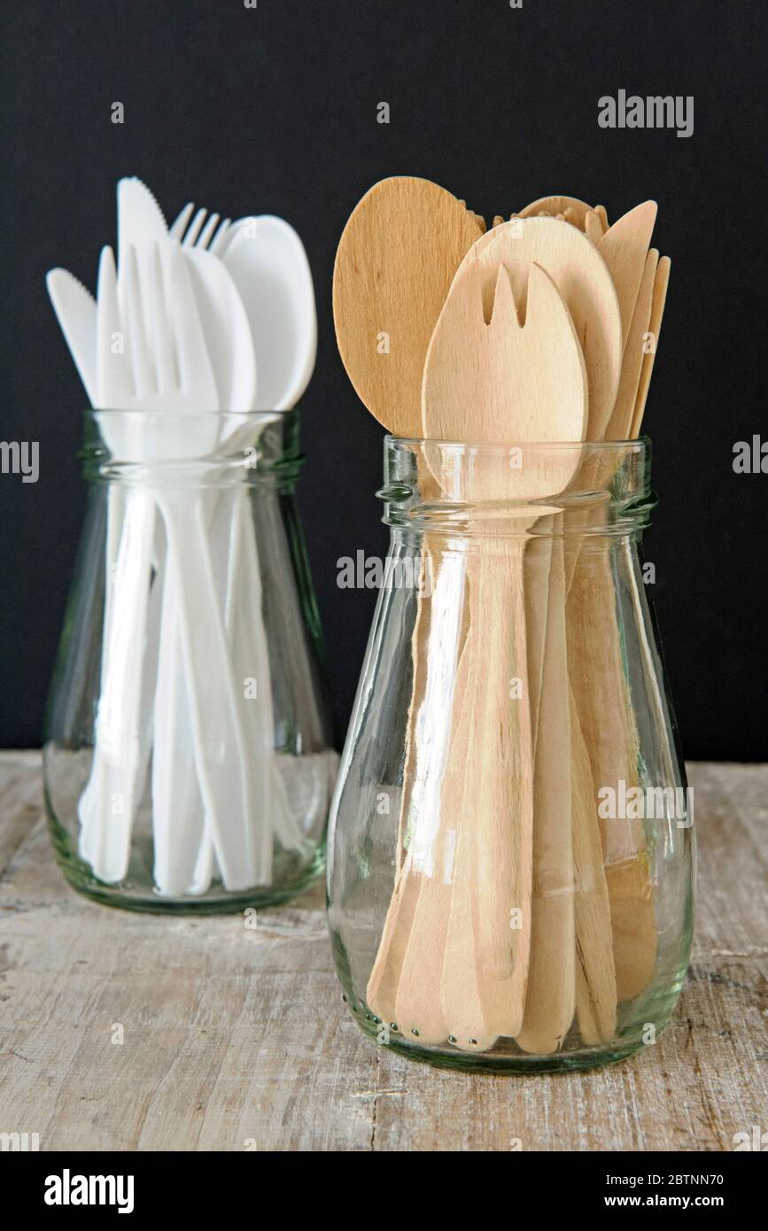 Reused wooden and plastic cutlery stored in glass jars against black background.  No need to throw away, just wash and reuse.  Zero waste concept. Stock Photo