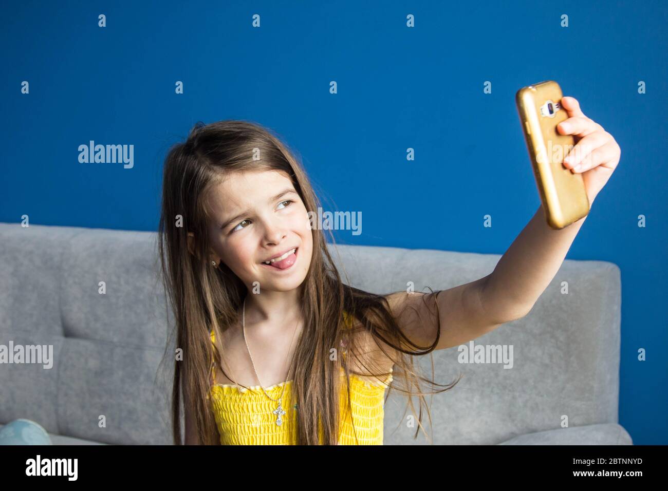 girl takes a selfie on her phone in a room with blue walls Stock Photo ...