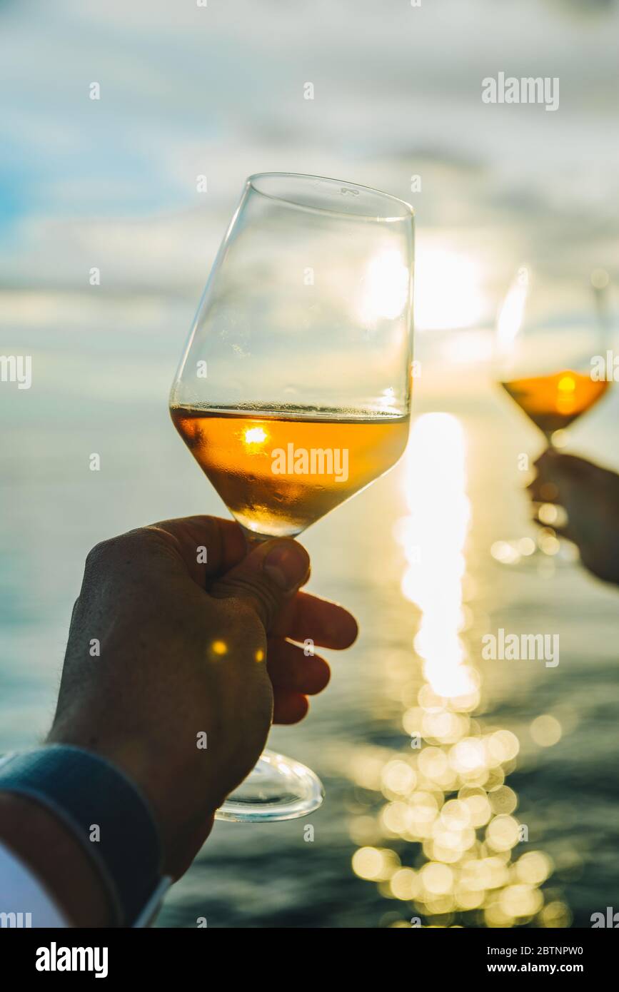 couple resting on sunset at sea beach and drinking wine Stock Photo - Alamy