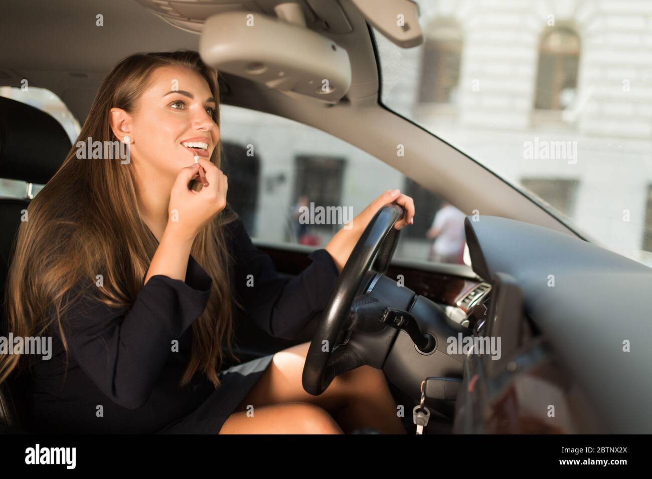 Frau mit Lippen im Schminkspiegel, während sie im Auto sitzt. - ein  lizenzfreies Stock Foto von Photocase
