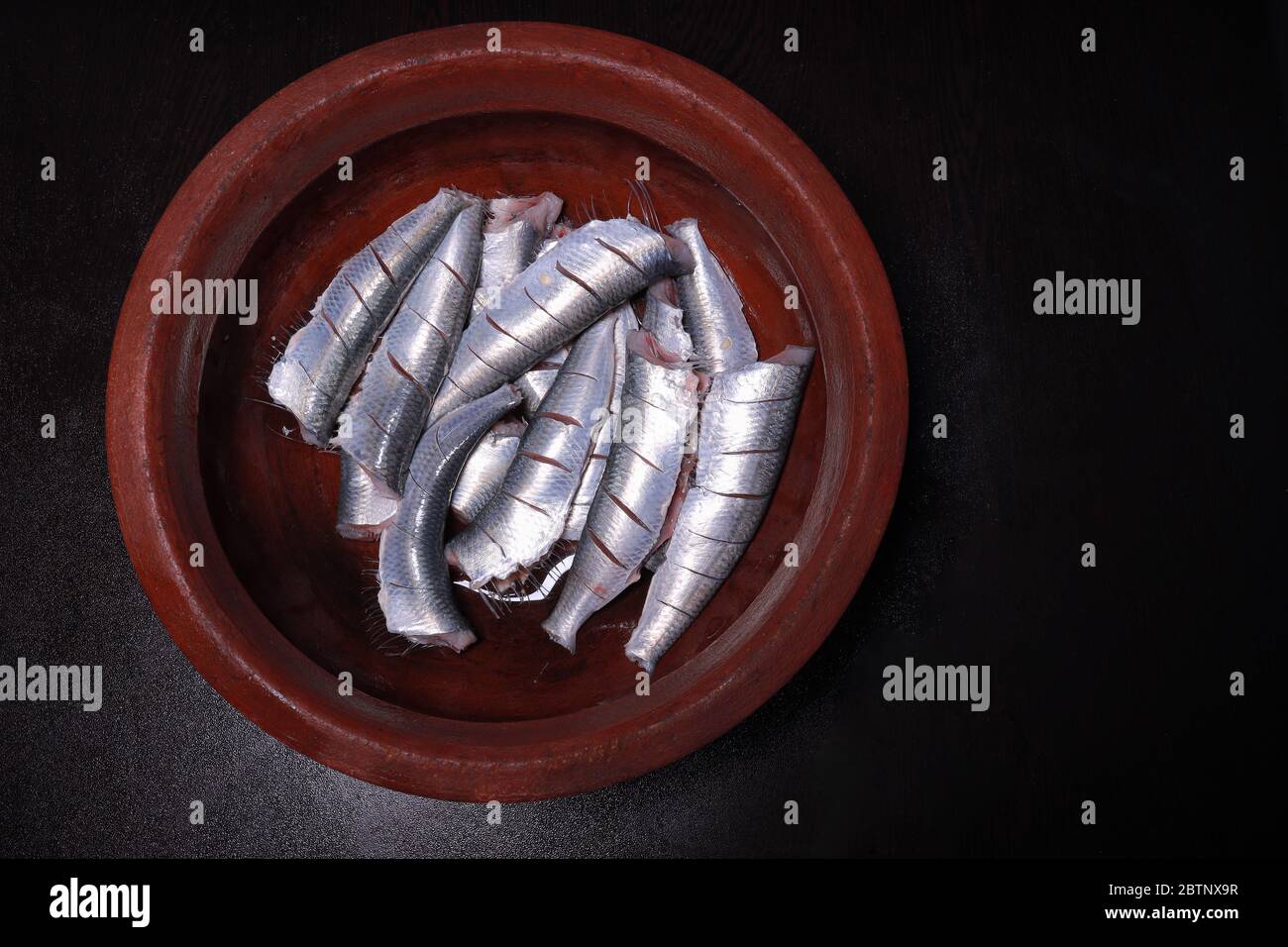 Fresh sardines cut head and being prepared for cooking south indian