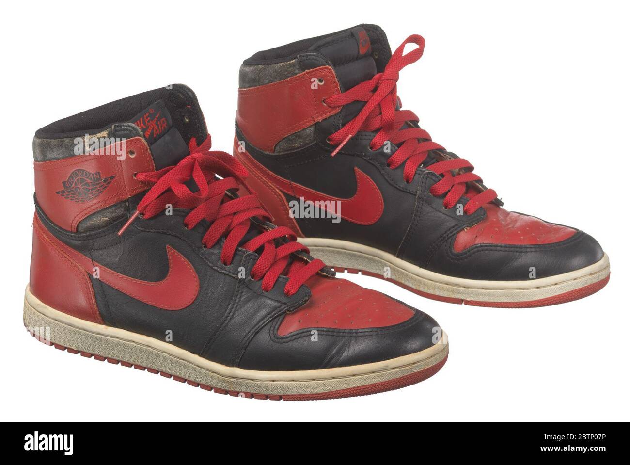 Pair of red and black Air Jordan I high top sneakers made by Nike. A pair  of Nike brand red and black Air Jordan I high top sneakers, also known as  the "