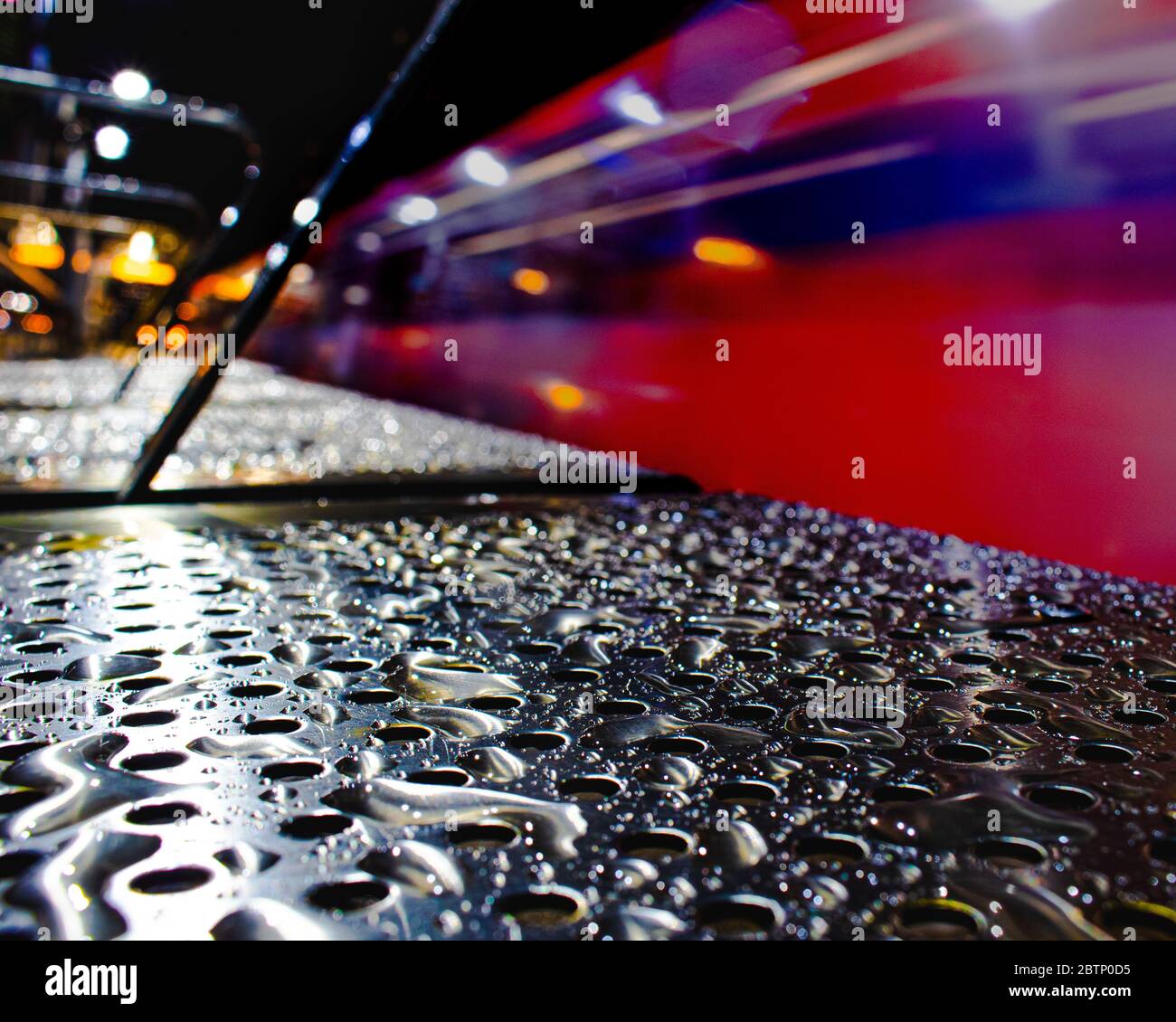 Water droplets on a bench as a train passes through Blackwall DLR Station Stock Photo