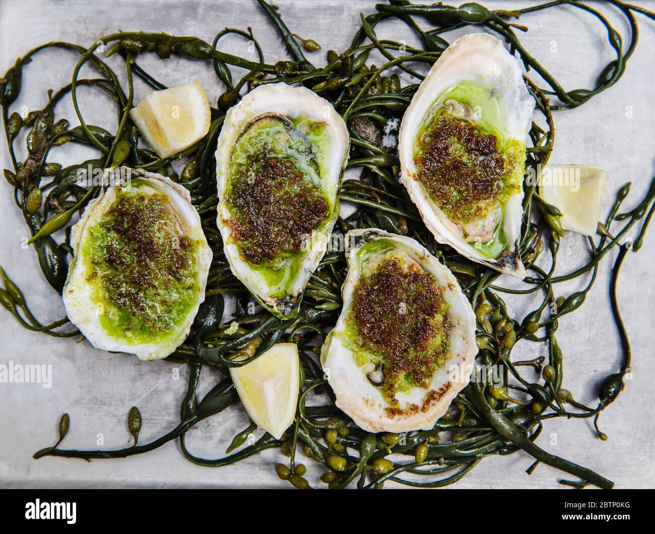 Grilled oysters with herb butter and lemon Stock Photo Alamy