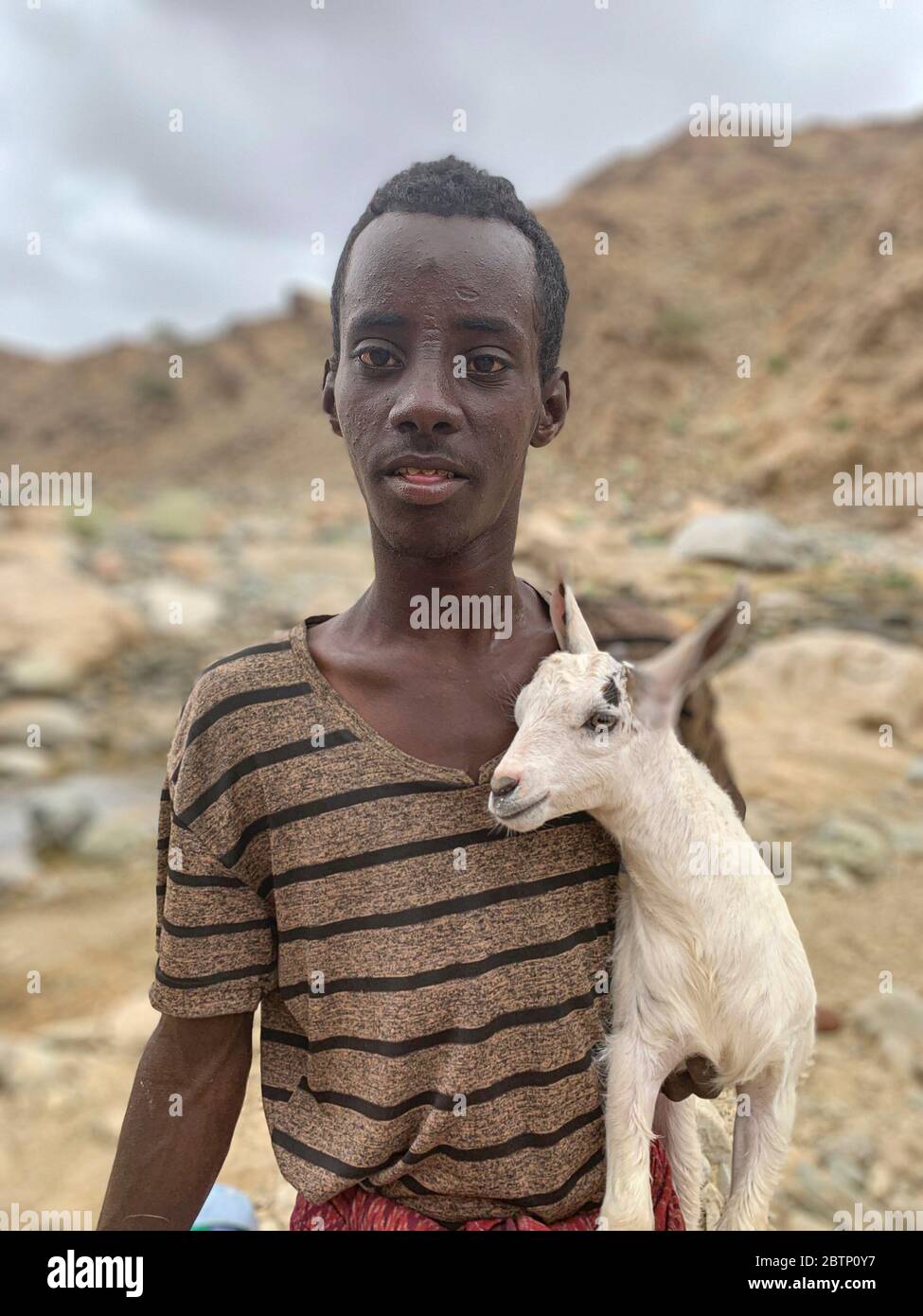 Afar boy holding a small goat, Ethiopia, Africa Stock Photo