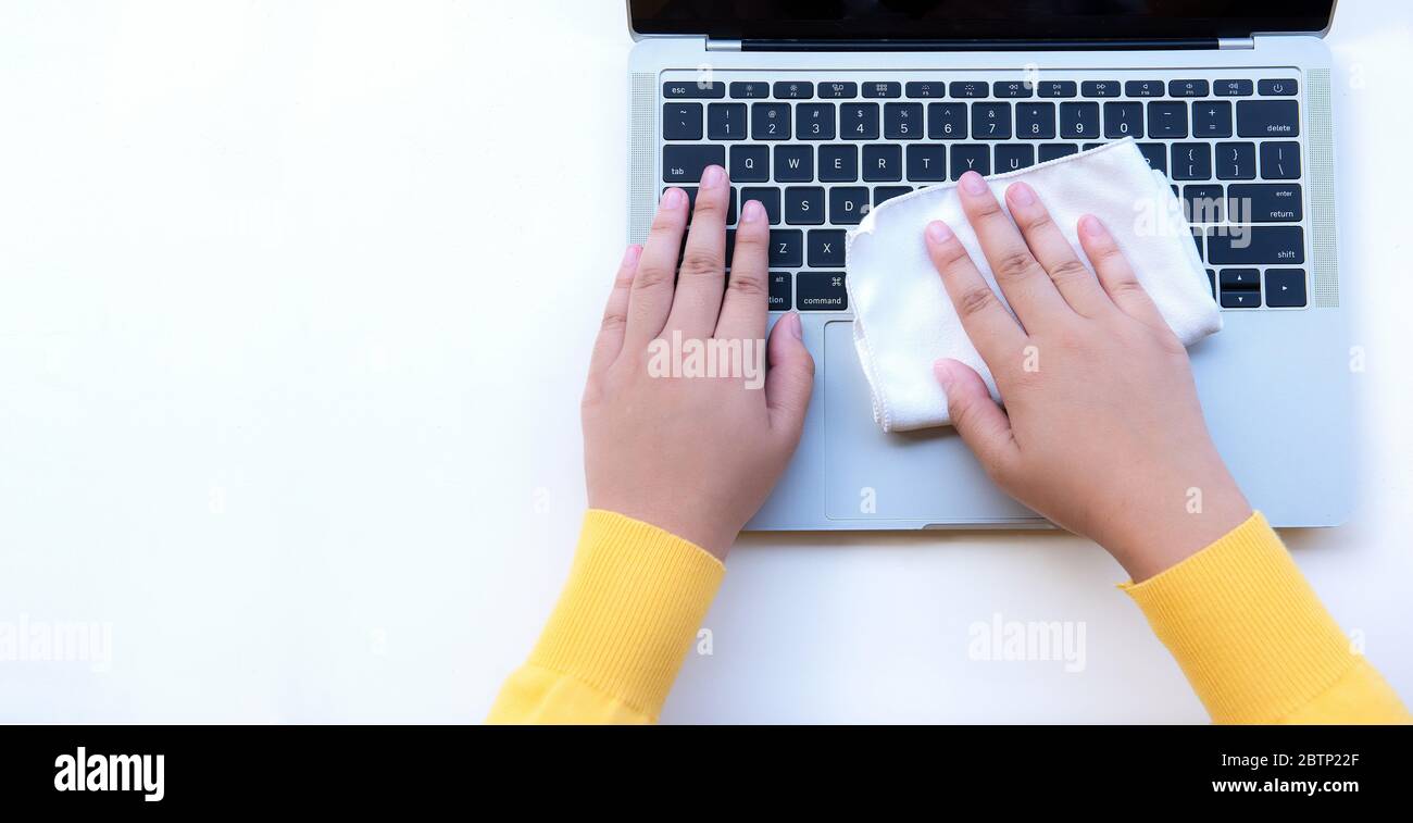 Flat lay lady hand is using a laptop cleaning cloth on whithe background Stock Photo