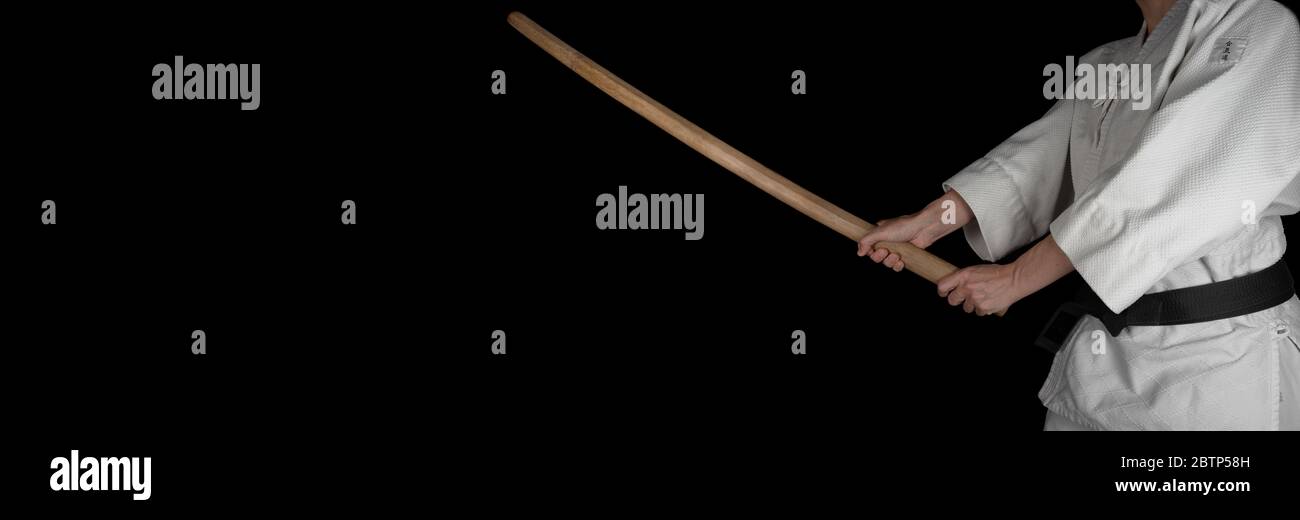 A person practicing aikido on a black background. Stock Photo