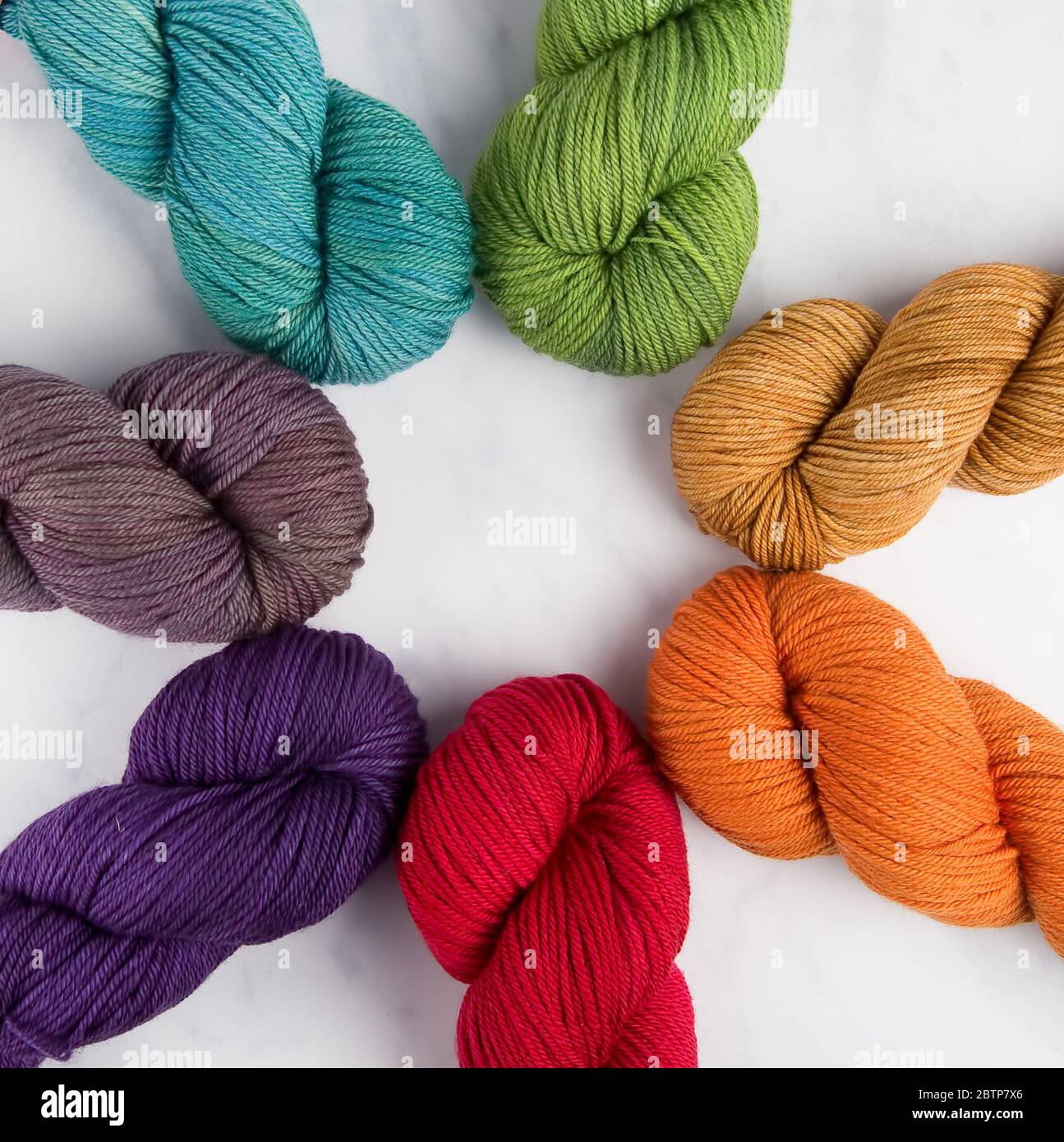 A rainbow of woolen yarn hanks arranged in a circle Stock Photo