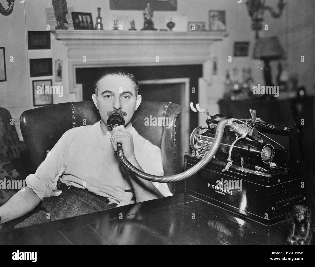 An unconventional worker . Mr Gilbert Frankau engaged on a new novel at his flat in Lincoln 's Inn . He dictates all his work to the Dictaphone . 19 February 1932 Stock Photo