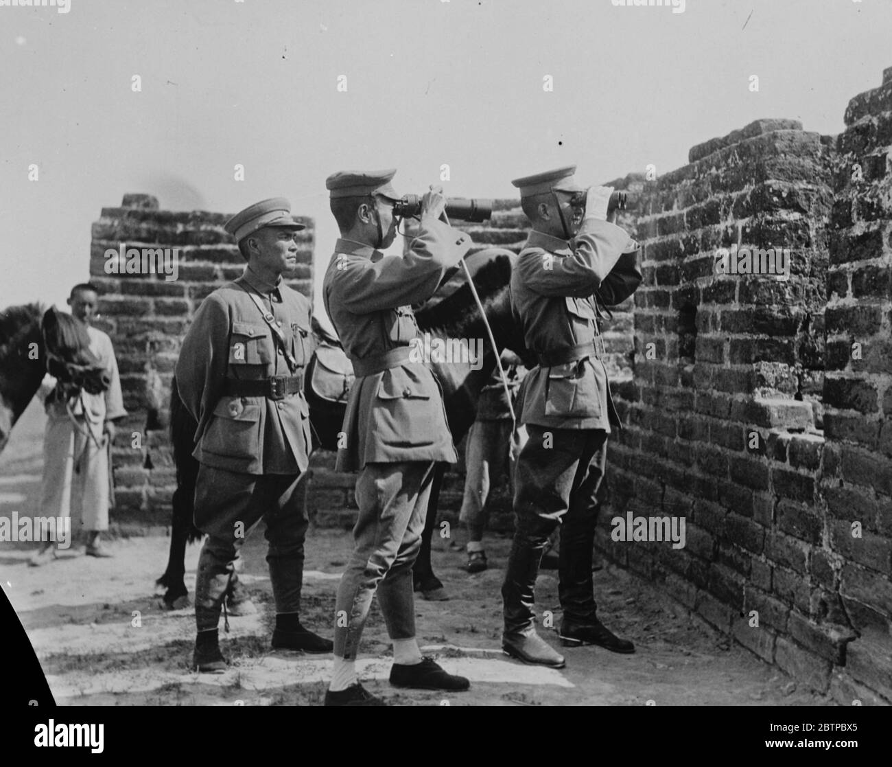 Latest photographs from China . General Bei Chung Shi ( nearest wall ) and his chief of staff , watching the retreating Northern Army . He is in Command of the Nationalist army . 8 August 1927 Stock Photo