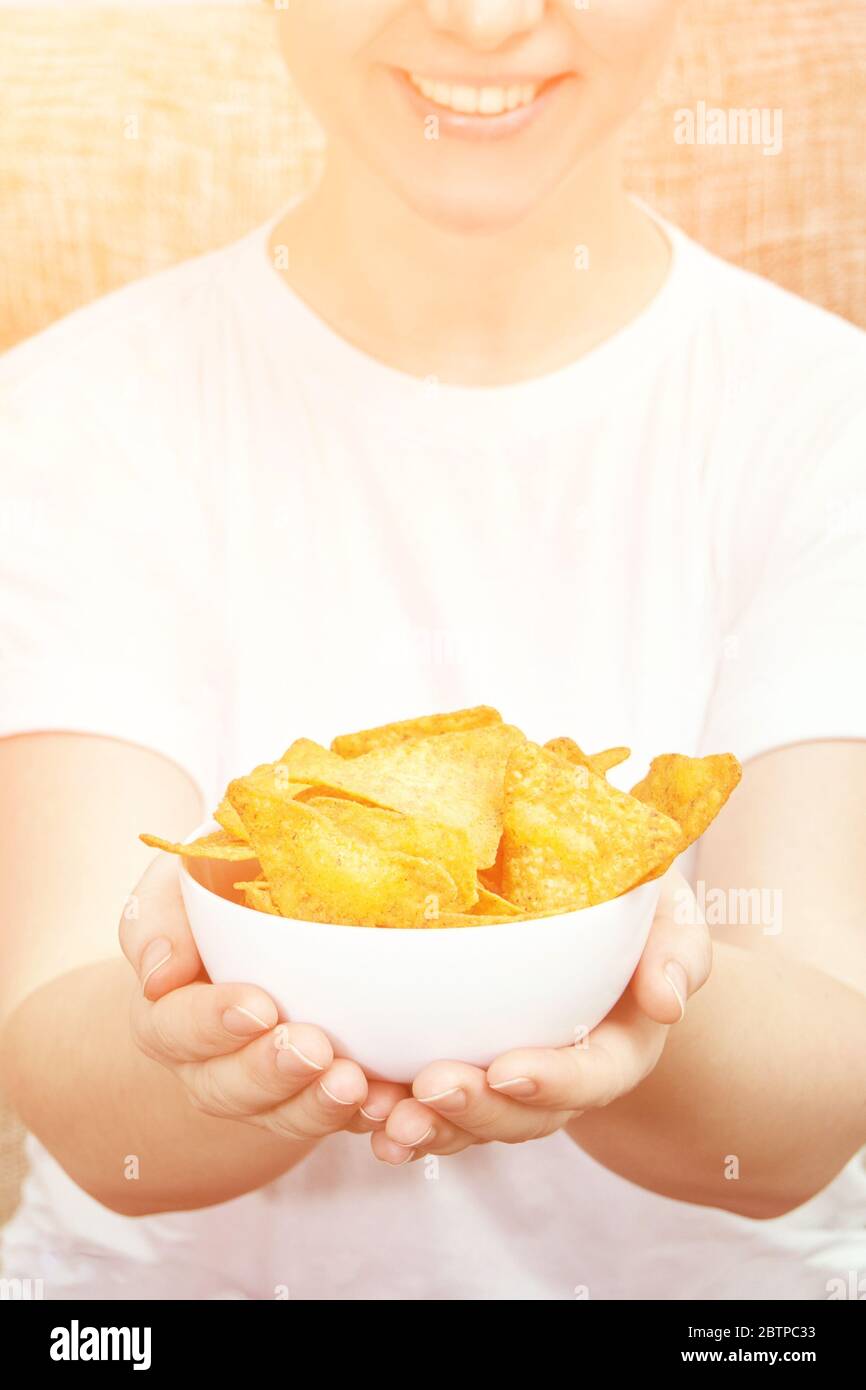 Girl holding at hands chips bowl. Stock Photo