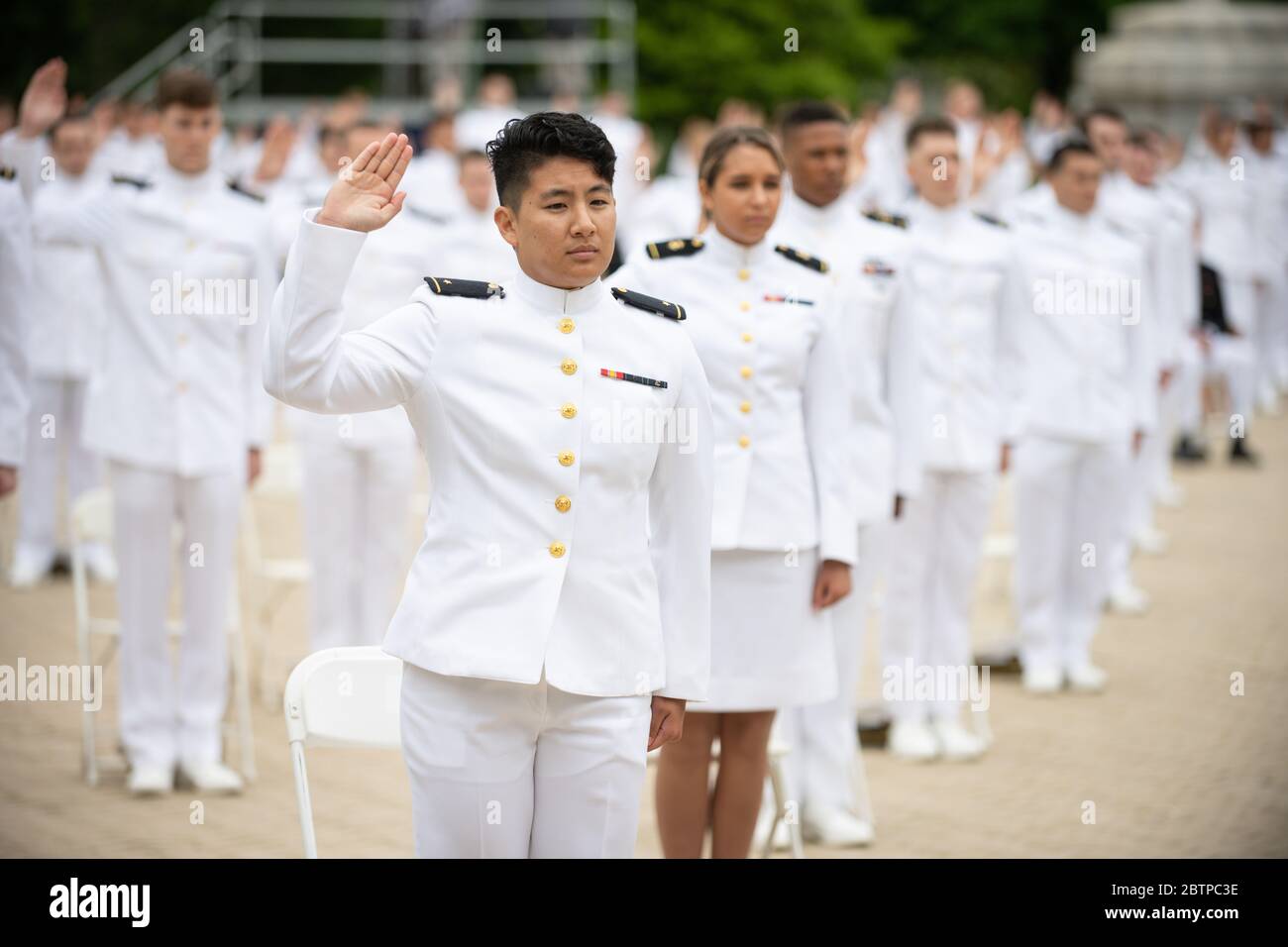 U.S. Naval Academy Navy midshipmen take the oath of service during the commencement and commissioning ceremony for the Naval Academy Class of 2020 under COVID-19, coronavirus pandemic social distancing rules May 18, 2020 in Annapolis, Maryland. Approximately 1,000 midshipmen will graduate and be sworn-in during five events and one virtual ceremony. Stock Photo