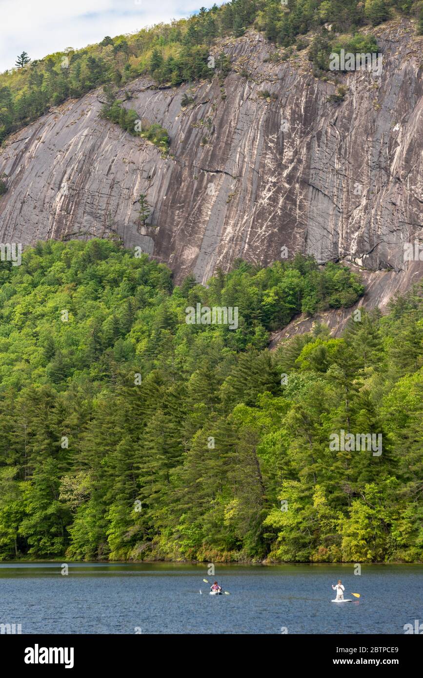 Kayaker and paddleboarder on Sapphire Valley Resort's Fairfield Lake beneath Bald Rock Mountain near Cashiers in Western North Carolina. (USA) Stock Photo