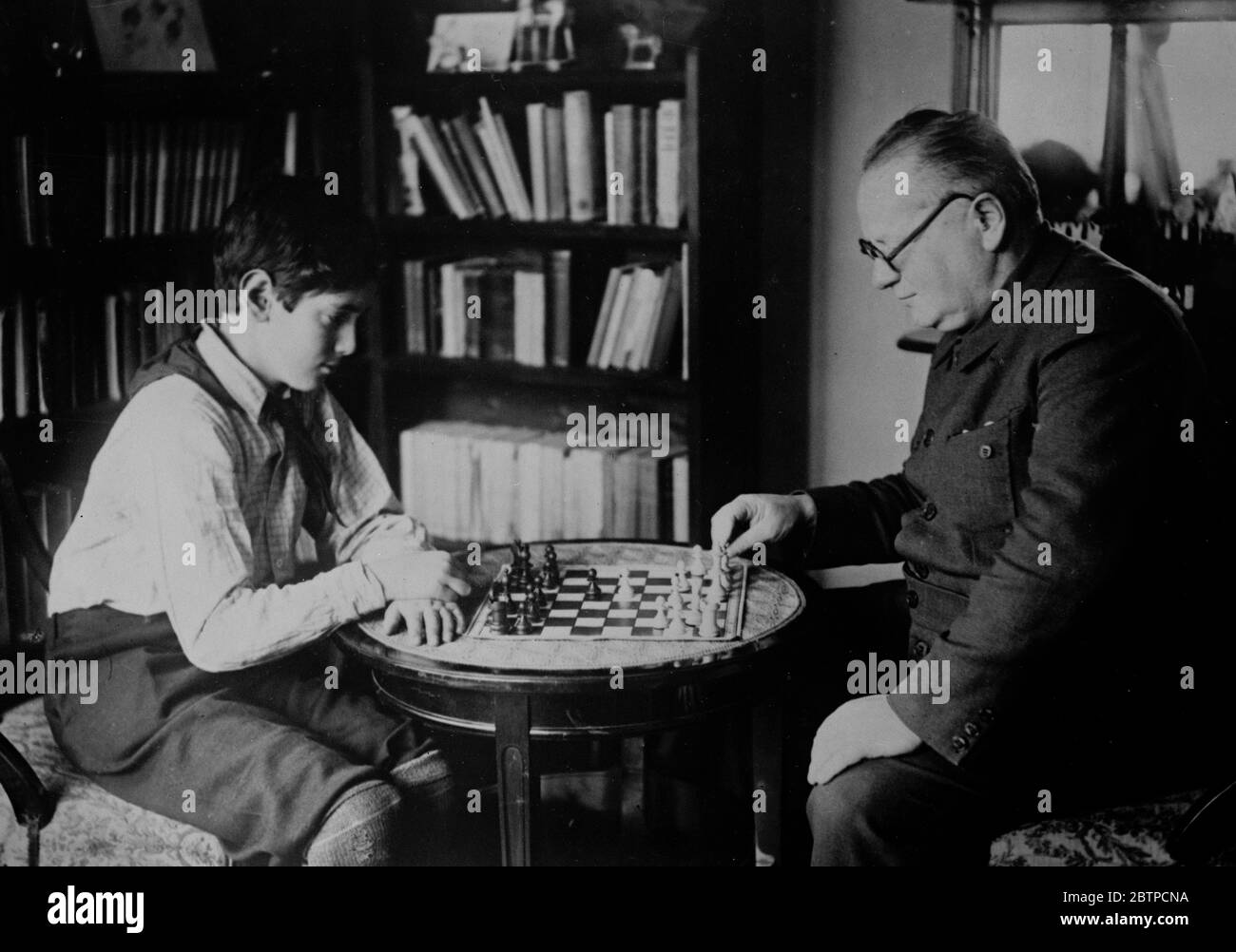 In a new role . Maxim Litvinoff , the Bolshevist who was recently given carte blanche for the Runnian Policy playing chess with his little son Micha . 19 October 1932 Stock Photo
