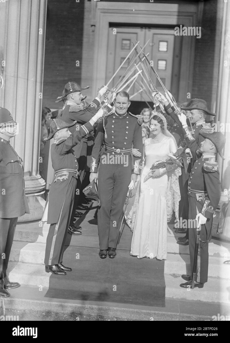 Naval officers wedding . The marriage took place at St Pater ' s , Eaton square , between Lieut E H Gelson Gregson , Royal Navy and Miss Mabel MacGregor . The bride and bridegroom leaving under an archway of swords . 3 October 1931 Stock Photo