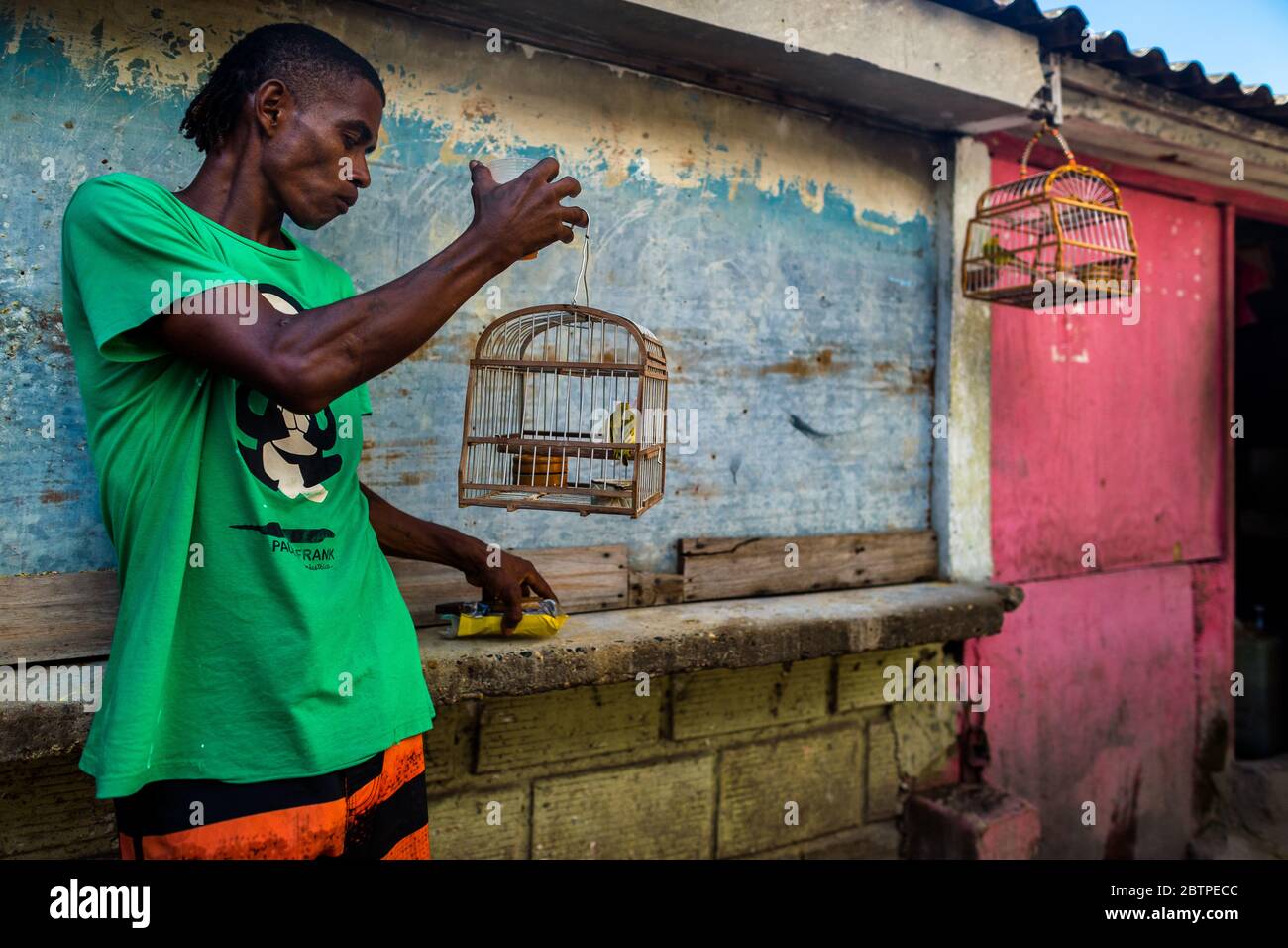 A Colombian bird vendor holds a birdcage, with a canary inside, in the bird market in Cartagena, Colombia. Stock Photo