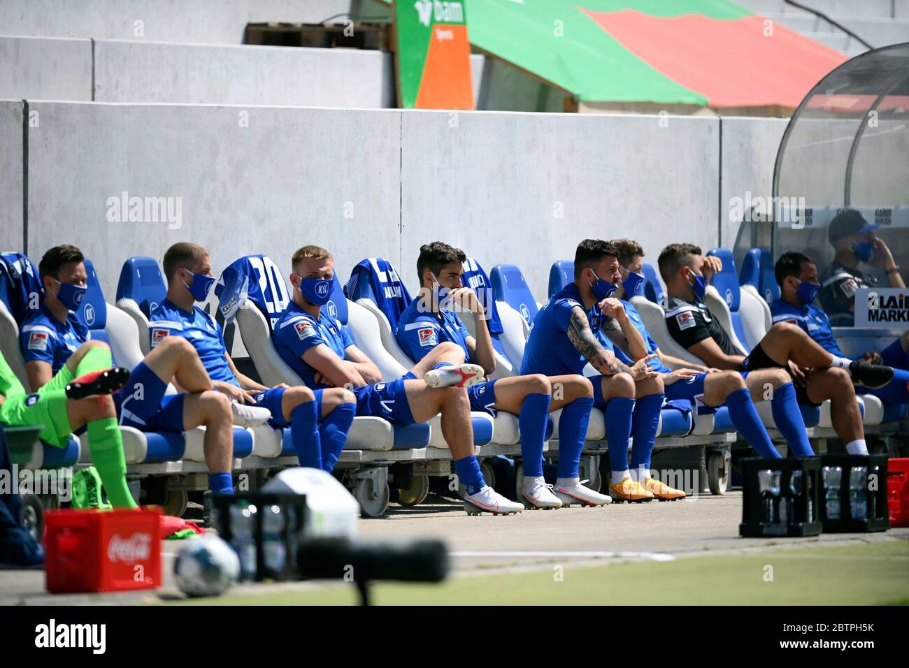 KSC players sit on the bench observing social distancing and wearing face masks to protect against coronavirus, sit on the bench during the 2nd Bundesliga soccer match beteween Karlsruher SC and SV Darmstadt 98, in Karlsruhe, Germany, Saturday, May 16, 2020. Professional soccer has resumed after a two-month break in Germany with four games in the second division. Stock Photo