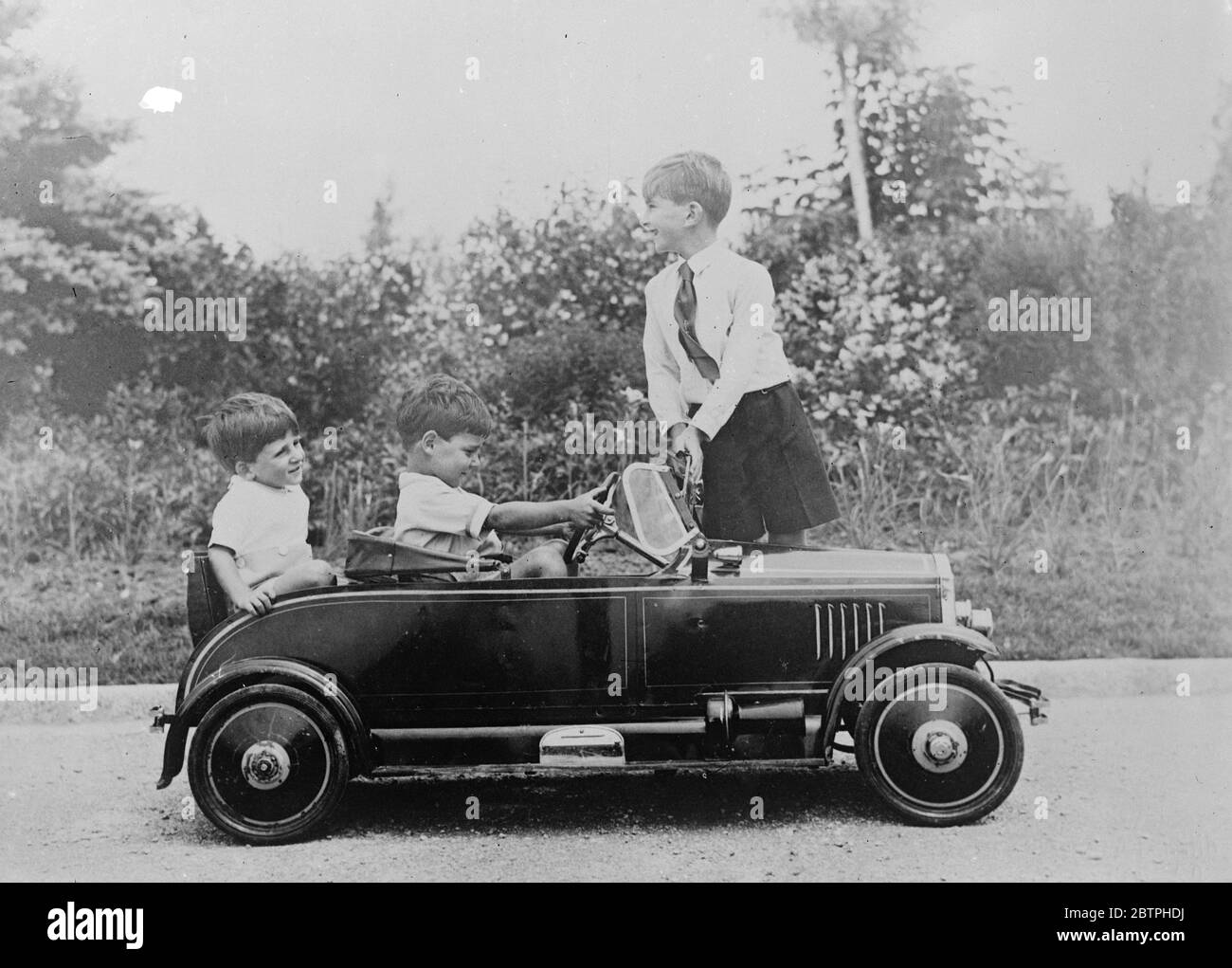 Royal motorists . Crown Prince Peter of Yugoslavia and his two younger brothers are ardent motorists and spend much time in the grounds of their summer home in their luxurious model car . Crown Prince Peter giving instruction in the rudiments of motoring to his younger brothers Prince Tomislav and Prince Andrija while playing in the grounds of Bleb Palace in Slovenia , where they are spending the summer . 21 June 1932 Stock Photo