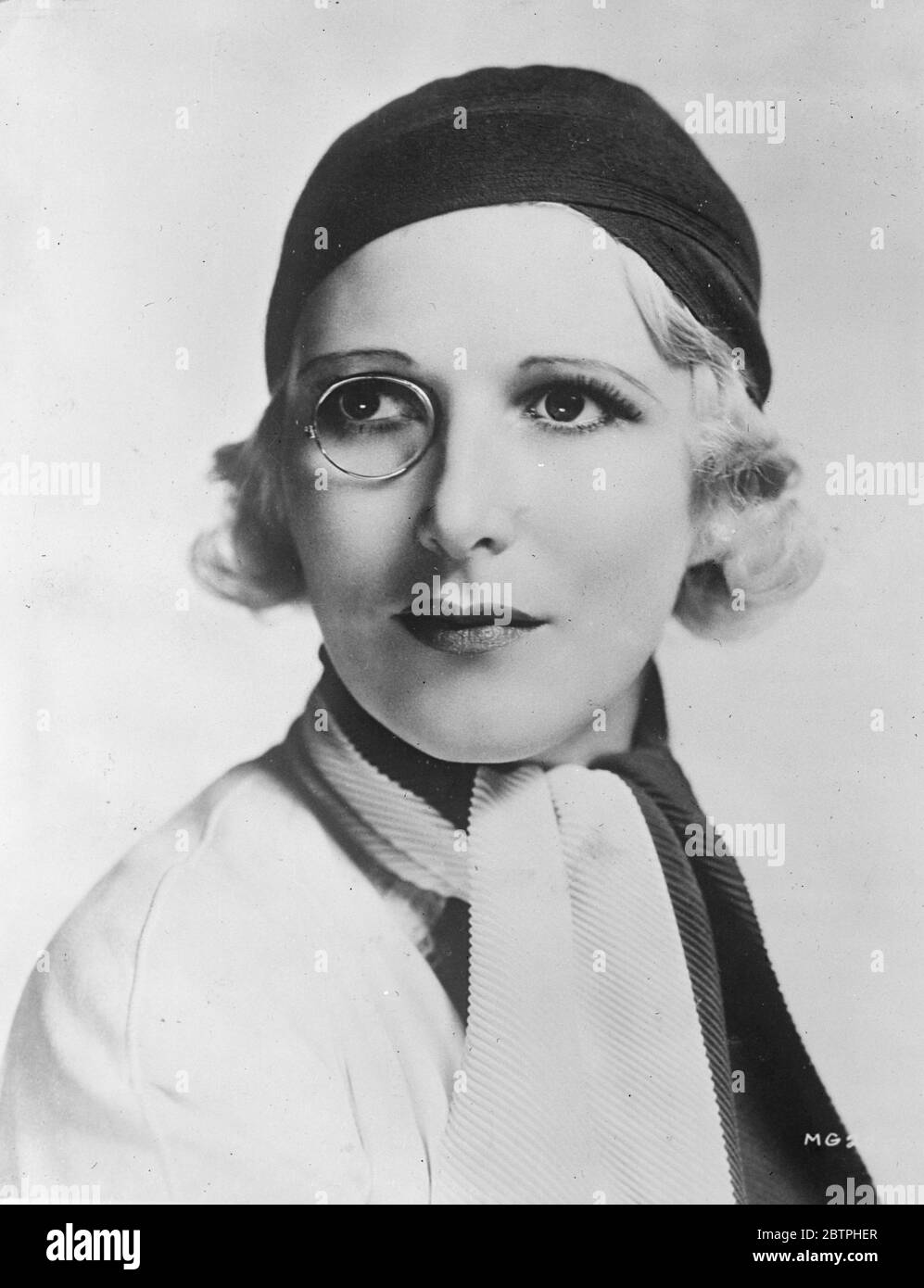 The monocled star . Heather Thatcher , the English actress with her monocle , and a new black and white scarf worn with a close fitting wool hat of black . 3 May 1932 Stock Photo