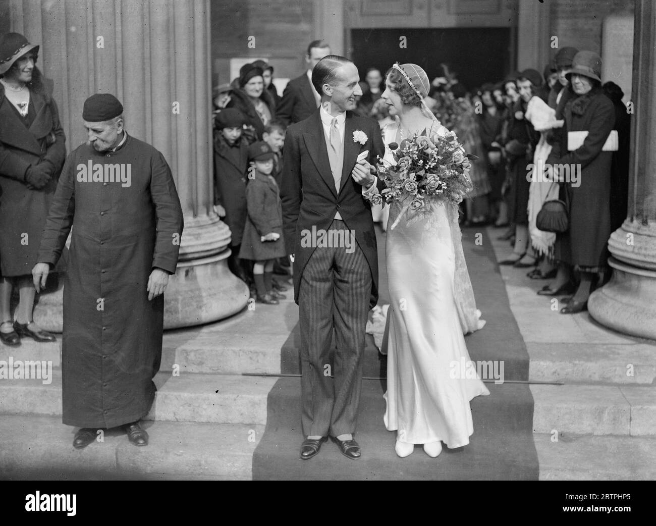 Pretty London wedding . The marriage of Mr P V Pelly and Miss P M Des Voaux , took place at St Peters Church , Eaton Square , London . The bride and groom after the ceremony . 19 March 1932 . Stock Photo