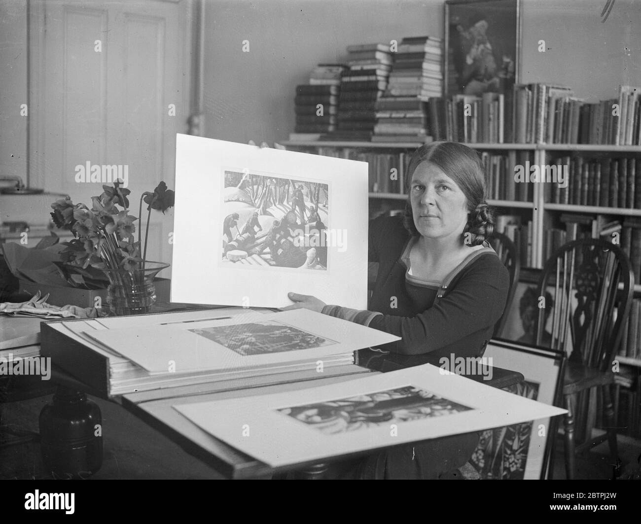 Woman artist honoured . Three women , Clare Leighton , Vanessa Bell and Winifred Nicholson, are included in the list of 24 contemporary British artists whose work will represent this country at the nineteenth International art exhibition at Venice this summer . Photo shows , Miss Clare Leighton with some of her work which will be exhibited , photographed in her London home . These are wood engravings some of which were done in Canadian lumber camps . 28 March 1934 Stock Photo