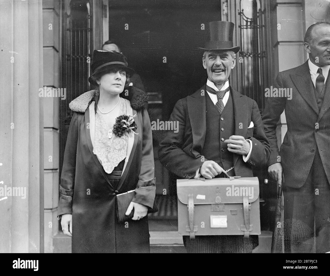 Budget Day, 1934. Mr Neville Chamberlain , accompanied by his wife Mrs Anne Chamberlain , leaving home for the House of Commons. 17 April 1934 30s, 30's, 1930s, 1930's, thirties, nineteen thirties Stock Photo
