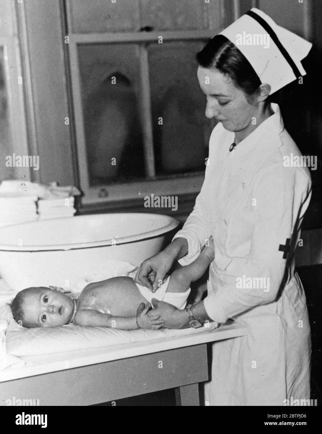 Dionne Quins . Cecile has her daiper fixed . Stock Photo