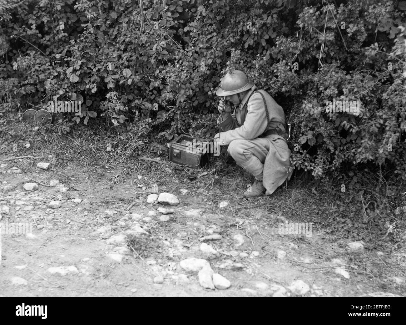 French army manoeuvres . A French telegraphist relays orders while hiding in a bush . 12 September 1934 Stock Photo