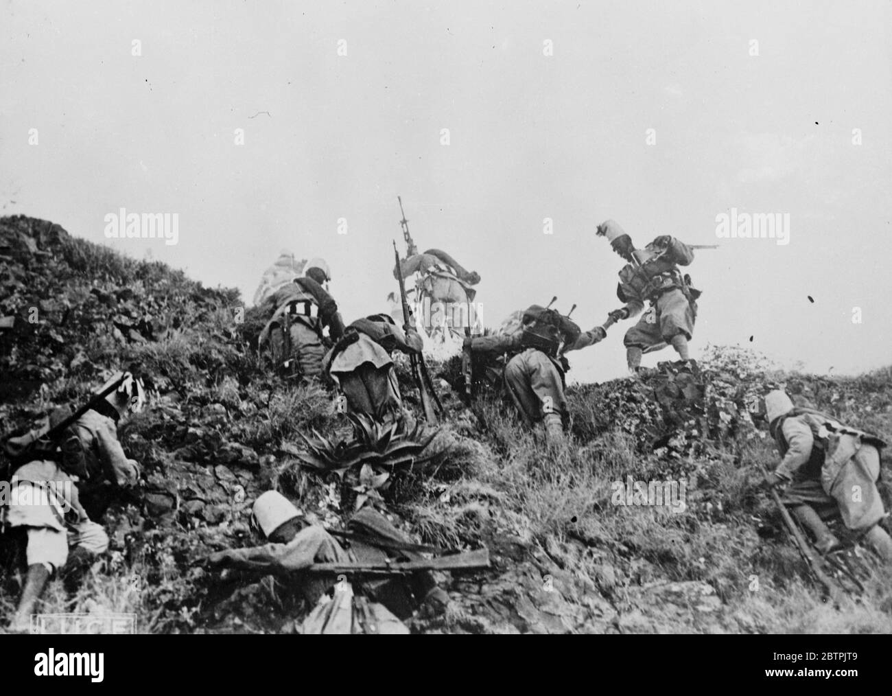 Italian advance on Makale . Colonel Lorenzini 's Askaris scaling a slope in the advance across the Danskil Desert to Makale . 7 November 1935 Stock Photo