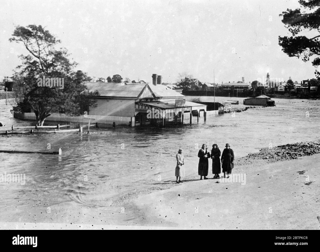 Flood Menace In Australia . Thousands Of Pounds Damage Follows Heavy Rains . Heavy rains have caused serious floods in the Eastern Gippsland district of Victoria , Australia . Thousands of pounds worth of damage has been caused to roads , livestock , homes and bridges . Many buildings have been submerged to the roof . Photo shows : Flood waters swirling around the Imperial Hotel at Bairnsdale , Eastern Gippsland . 13 Jul 1936 Stock Photo