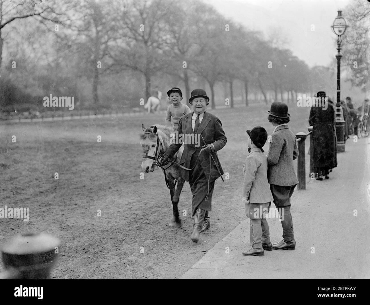 Hyde Park audience . Timothy Wardell having his riding lesson in the sunshine of Rotten Row , Hyde Park , watched by Jane and Timothy Taylor . 2 May 1936 Stock Photo