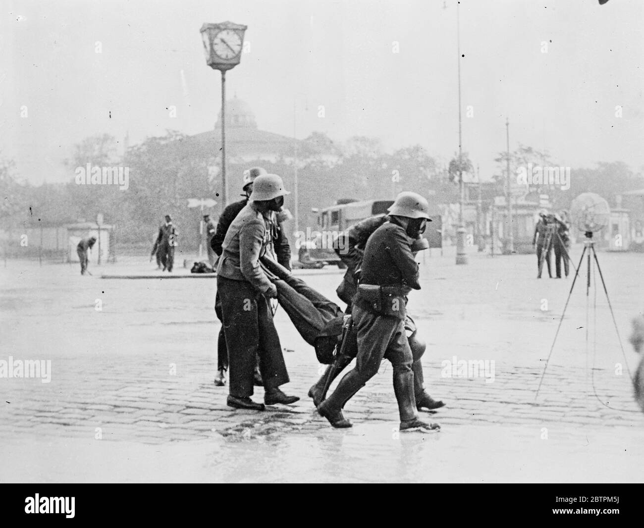 Air raid on Vienna . The anti air raid exercise organised in Vienna by the Austrian Government were the most realistic in the memory of Viennese . ' Poison gas ' rose in clouds , ' bombs ' exploded and firemen and first aid workers toiled amid the wreckage of buildings and vehicles . Photo shows , Gas masked police carrying a victim to safety 16 September 1935 Stock Photo