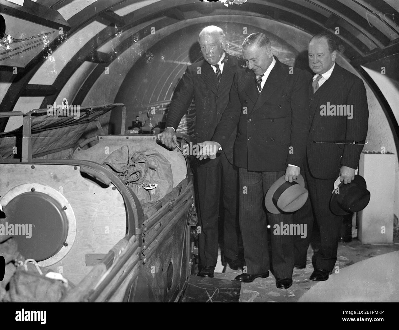 Post office ' s underground railway railway on a view at Charing Cross exhibition . Sir William Crawford opened the post office exhibition in the vestibuls of Charing Cross Underground station . The theme of the exhibition is Post Office services under the surface , on the ground and in the air . Photo shows , left to right , Lord Ashfield head of London Transport , Sir W J Womersley , Assistant Postmaster General and Sir William Crawford inspecting a section of the Post Office tube railway , which together with a replica of one of its stations , is a feature of the exhibition . this railway c Stock Photo