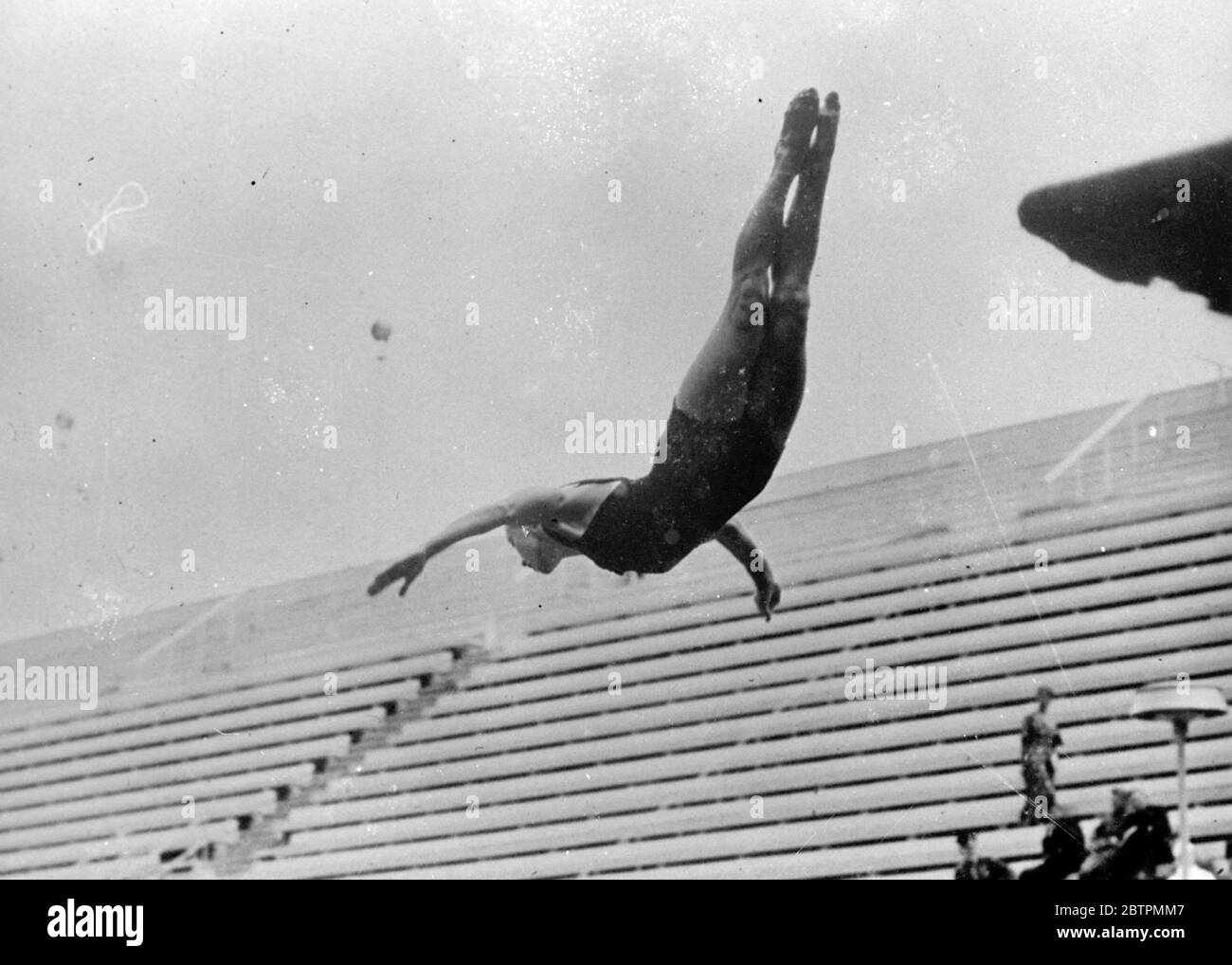 Gliding Down Members of the American high - diving team , including 13 - year - old Marjorie Gestring , are putting in final practise in Berlin before the opening of the 1936 Olympic Games next week . Photo shows : Dorothy Poynton , of America , swooping down in a graceful swallow dive as she practisees in Berlin . 31 Jul 1936 Stock Photo