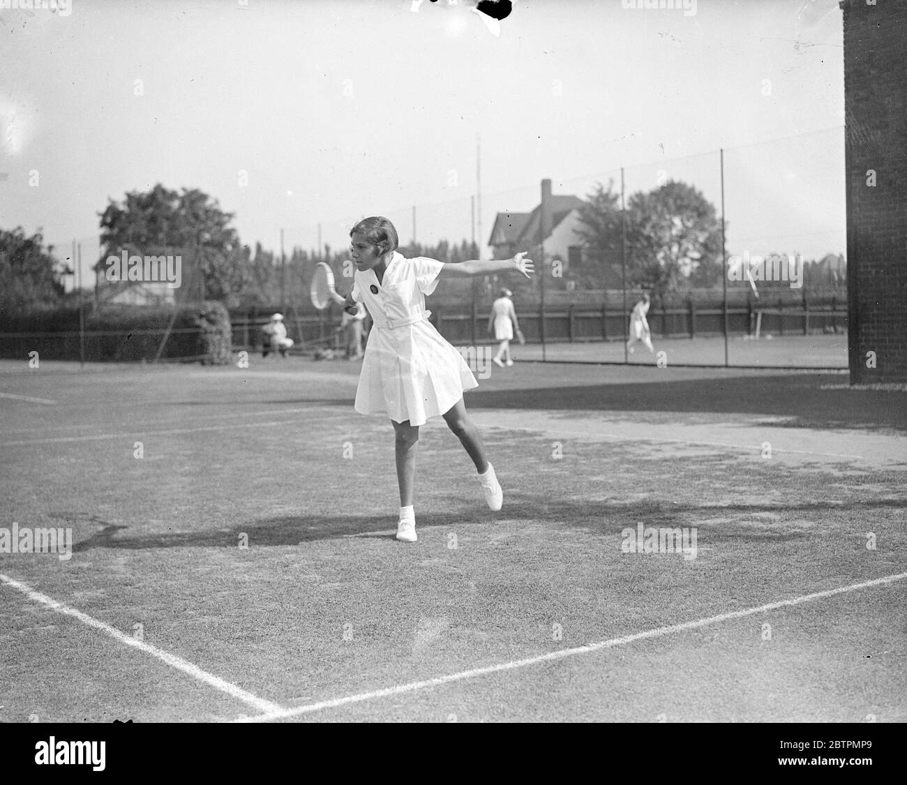 Determination . Twelve year old girl wins in Essex junior tennis tournament . The Essex Junior tennis Championships opened at Westcliff on Sea . Photo shows , Miss E A Brey , aged 12 , in play against Miss M J Belcham , whom she beat . 24 August 1936 Original caption from negative Stock Photo
