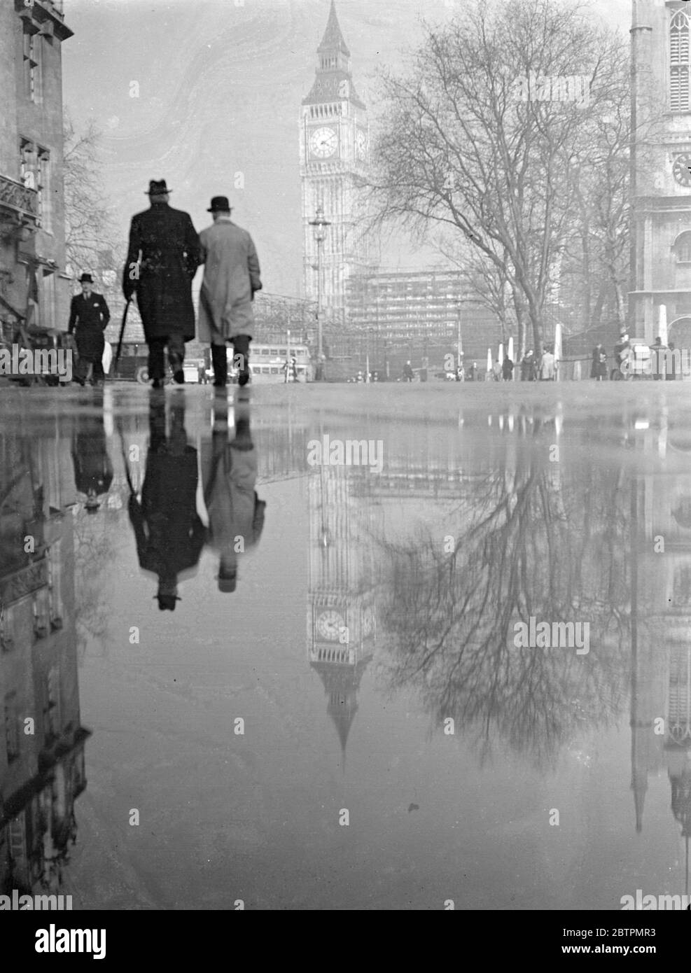 Mirror of time. The evening sun, shining on the wet pavements of Westminster after the heavy rain, reflects Big Ben as through in a giant mirror. 25 February 1937 Stock Photo