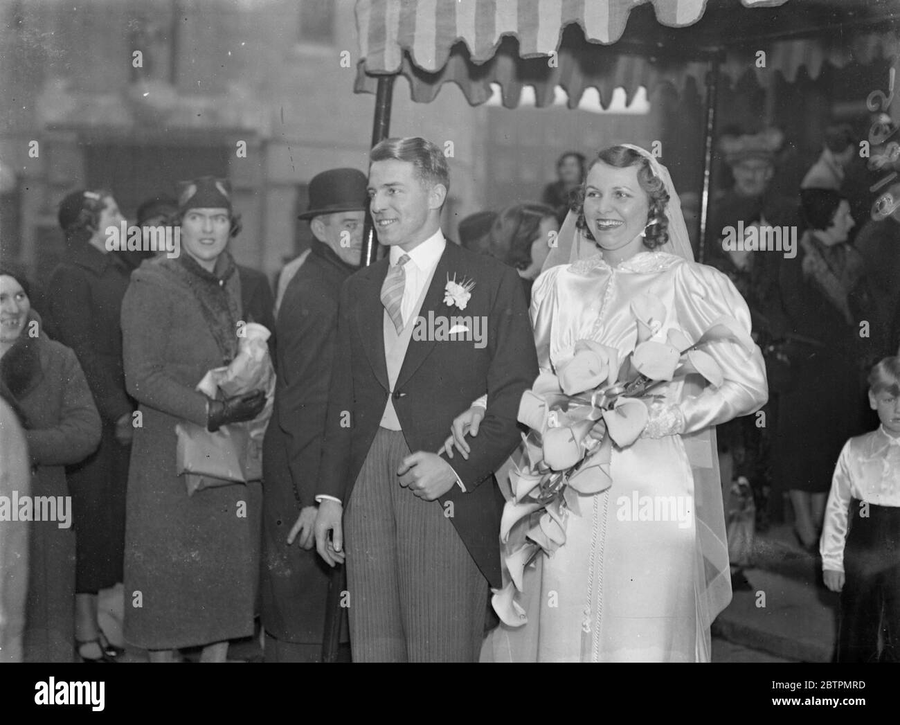Pretty West-End Bride. The wedding of Mr T Graham Humby and Miss Winifred Booth took place at All Souls' Church, Langham Place, London. Photo shows: The bride and groom after the ceremony. 24 February 1937 Stock Photo