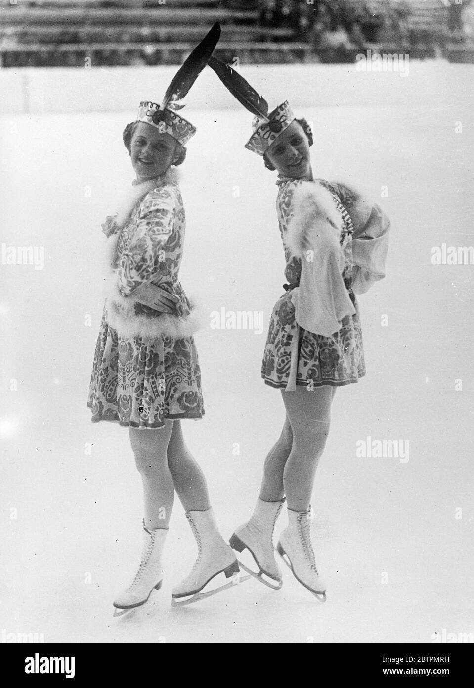 Girls peasant dance on skates. All the speed and intricate steps of a Hungarian peasant dance were contained in a skating display by the Von Botond sisters at Garmisch-Partenkirchen, which is celebrating an international winter sports week. The girls were dressed in a skaters adaptation of Hungary in national costume. Photo shows: the Von Botond sisters dancing in their Hungarian skating costumes. 27 January 1937 Stock Photo