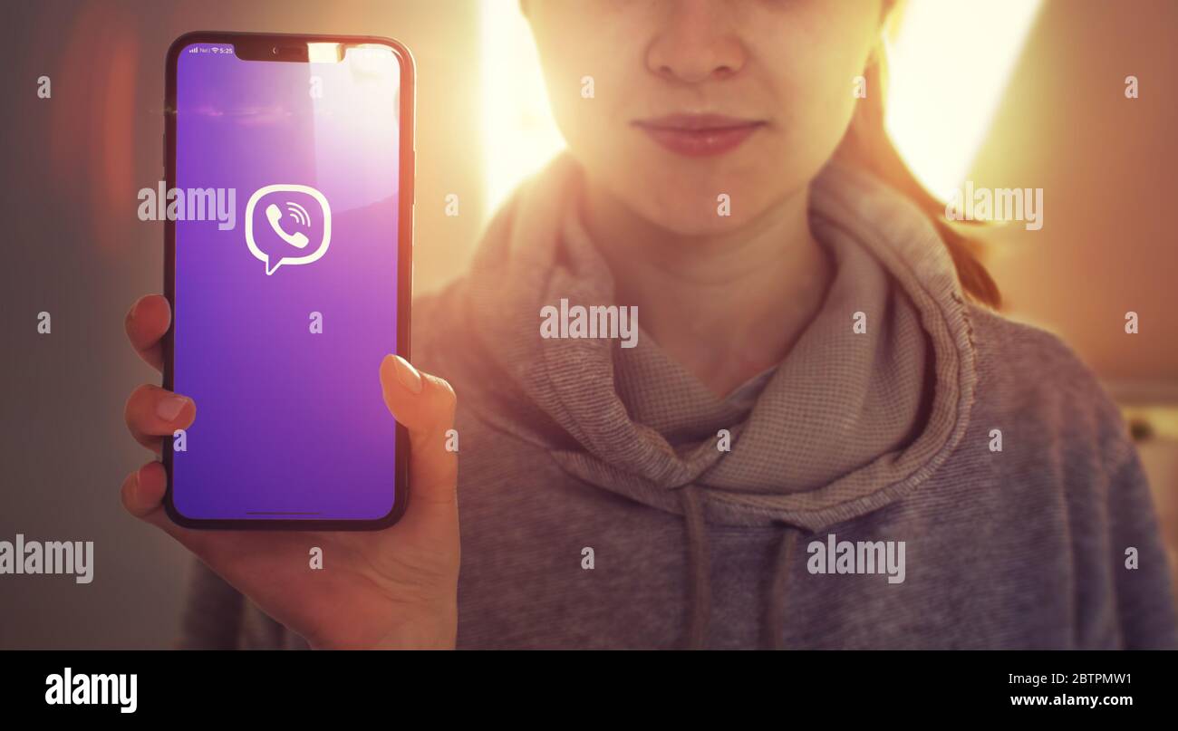 KYIV, UKRAINE-JANUARY, 2020: Viber on Mobile Phone Screen. Young Girl Showing Mobile Phone Screen with Viber on it while Looking at the Camera. Focus on Smartphone. Stock Photo