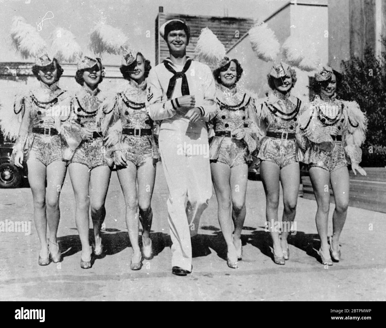 They are calling all stars! Photo shows: a sailors dream come true-but it happened in Hollywood! The sailor is a dancer (no further detail available) 22 October 1936 Stock Photo