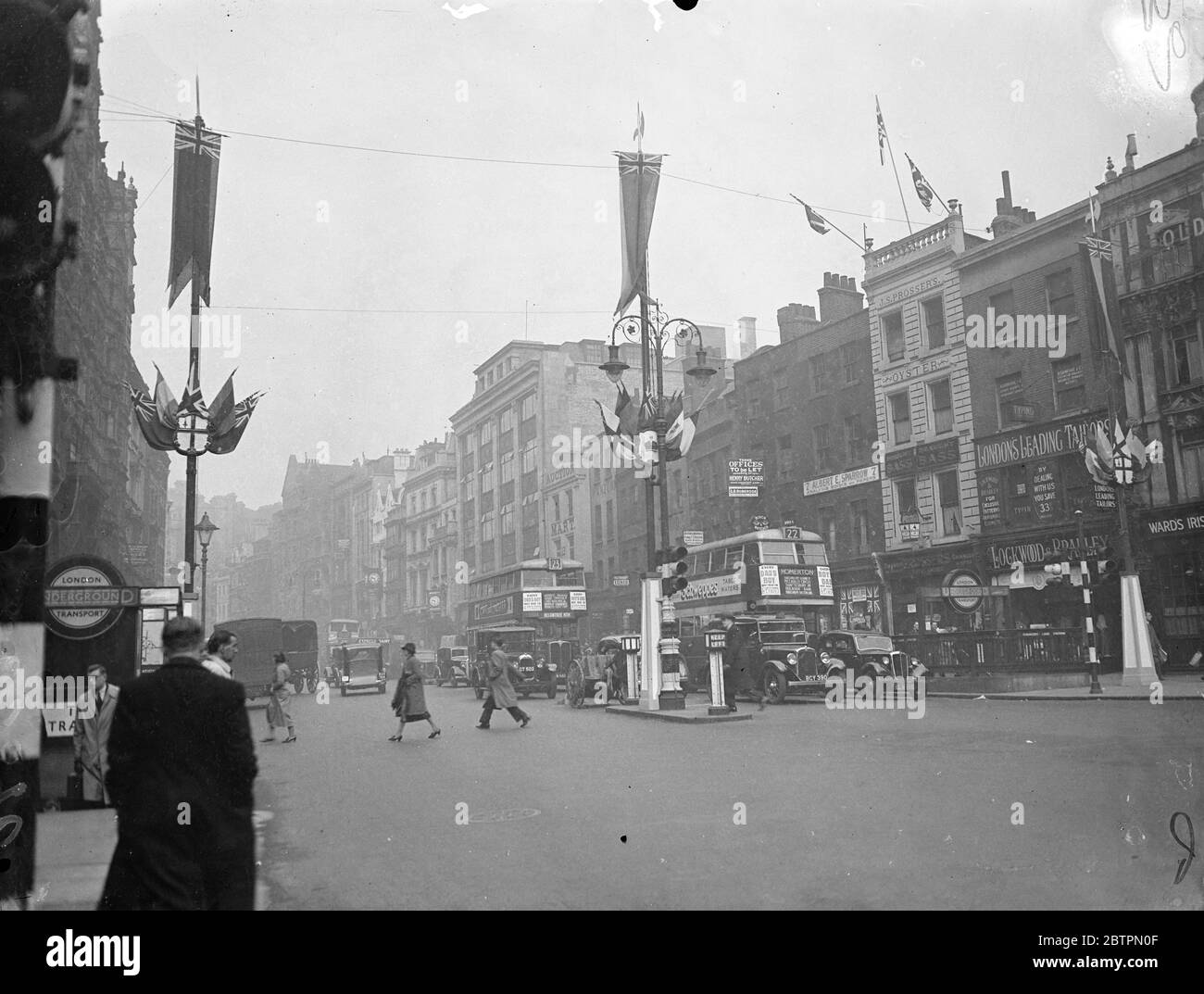 Coronation decorations in Holborn. Photo shows: Coronation banners being erected in easy Holborn near Gray's Inn Road. 27 April 1937 Stock Photo