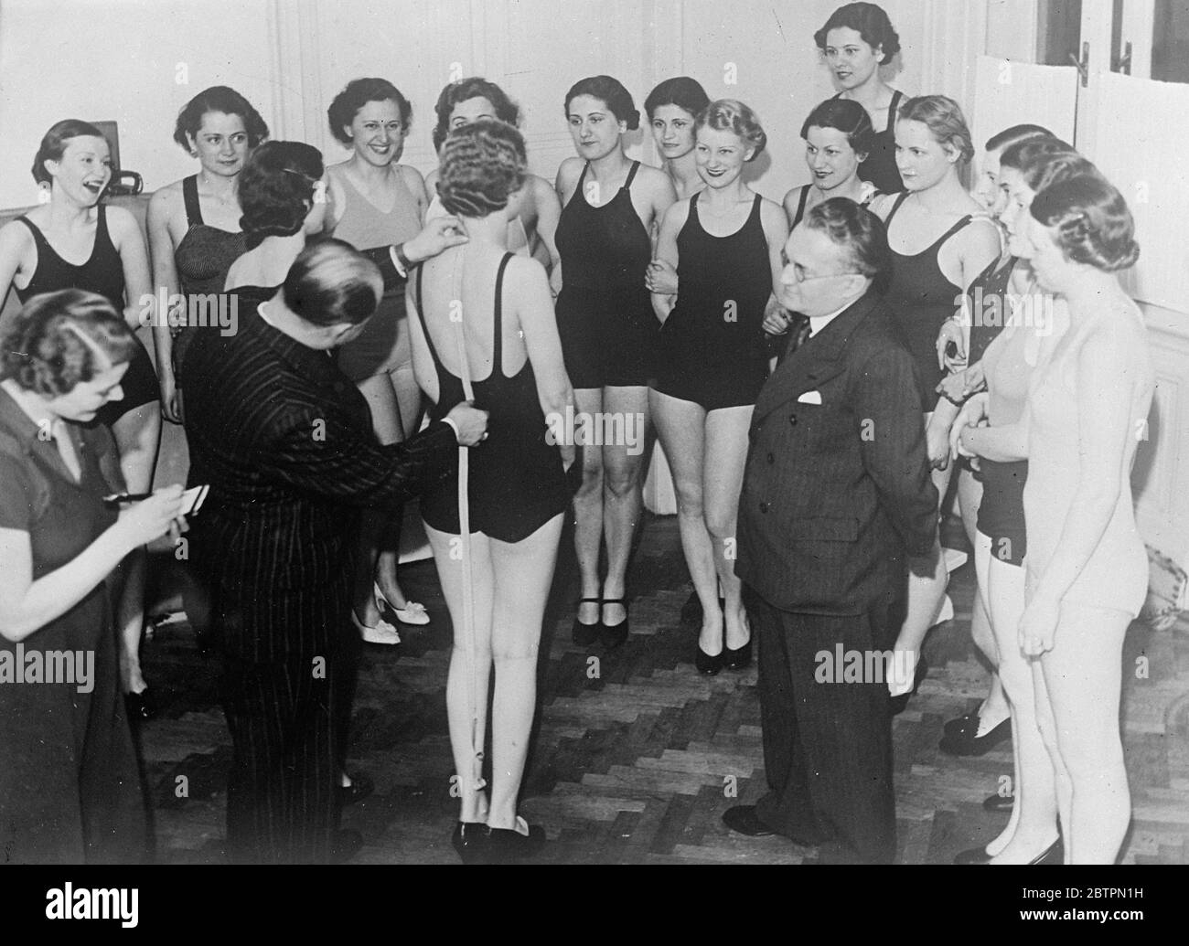 School for mannequins in Vienna. The school has been open in Vienna to train young girls as mannequins. The girls are taught correct posture to give them perfect carriage or walk with a large ball balanced on the head. Photo shows, measuring prospective mannequins at Vienna School. Stock Photo