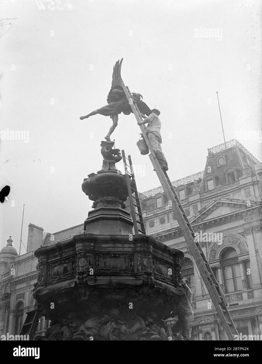 Eros brightened up for Coronation. You are in a workmen giving the Eros statue in Piccadilly Circus a 'Brush ups' so that he will give a bright welcome to the Coronation crowds. 16 April 1937 Stock Photo