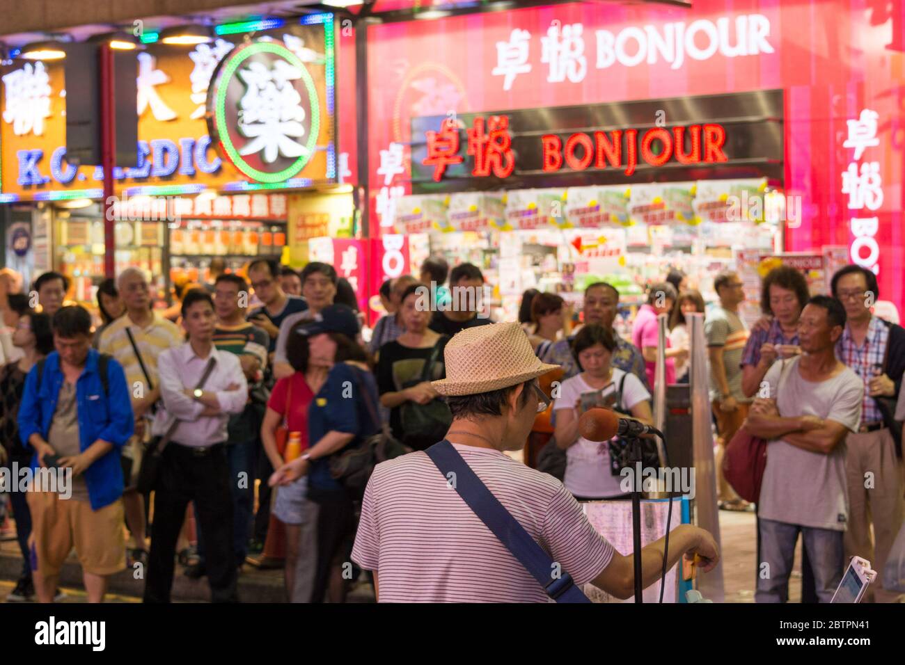 Hong Kong / China - July 26th 2015: Crowd listening to street musician performing in Kowloon, Hong Kong Stock Photo