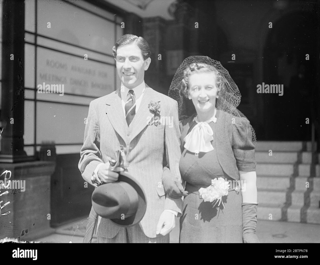Married in London wedding rush. Captain A. S. T. Godfrey, Royal Engineers, and Miss Muriel Abrahams, daughter of Major and Mrs A. C. Abrahams, who were married at Caxon Hall Register Office during the London rush of weddings which coincided with the wedding of the Duke and Duchess of Windsor. Photo shows: captain A. S. T. Godfrey and his bride leaving Caxon Hall after their marriage. 3 June 1937 Stock Photo