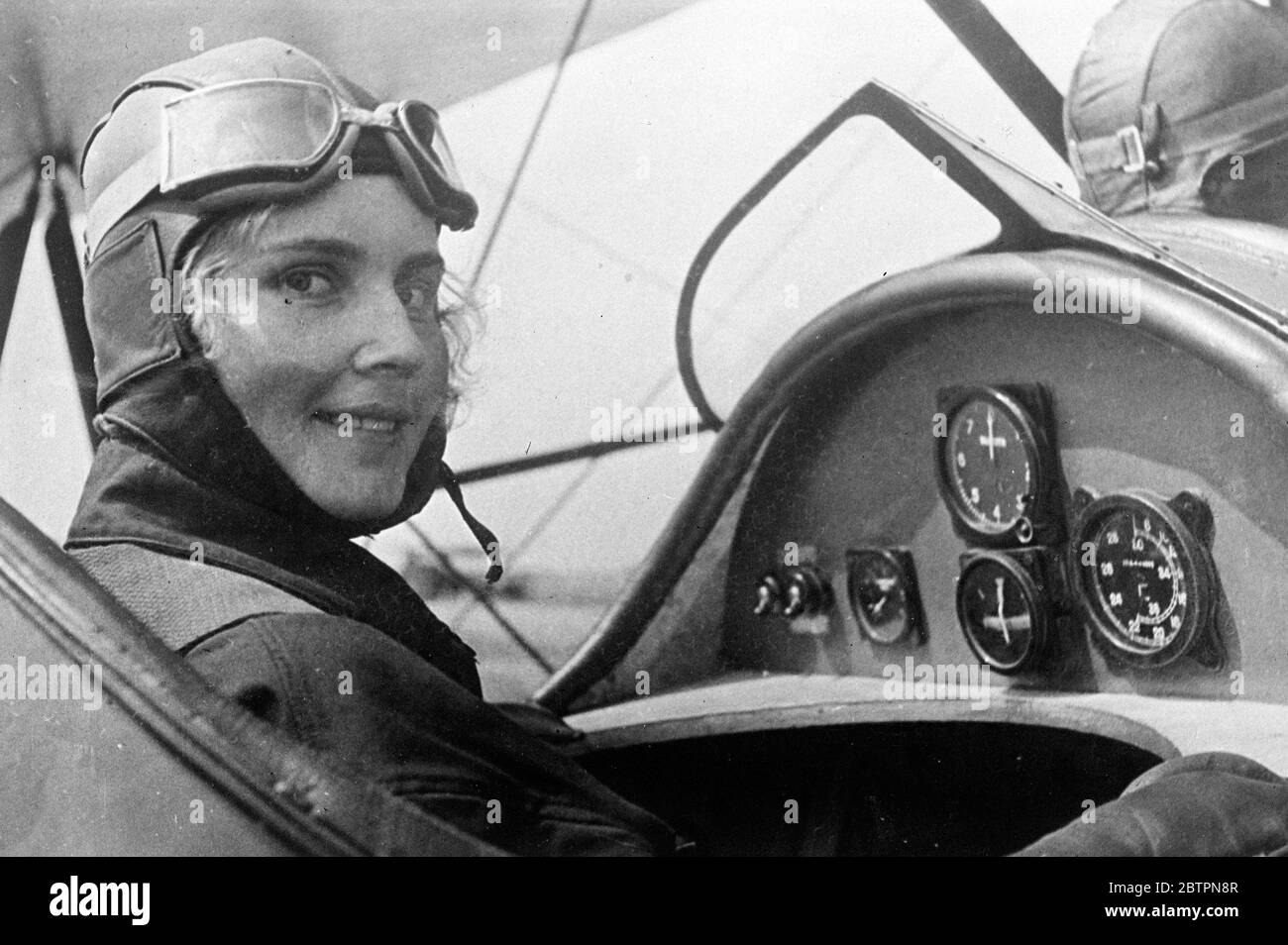 Russia's 'Queen of the air'. Attractive Matilda Gutnikova of Moscow, the Soviet Unions 'Queen of the air', photographed in the cockpit of the plane before taking off from the Moscow field on a flight. Matilda, a technician in a Moscow plant, learn to fly in her spare time. 13 June 1937 Stock Photo
