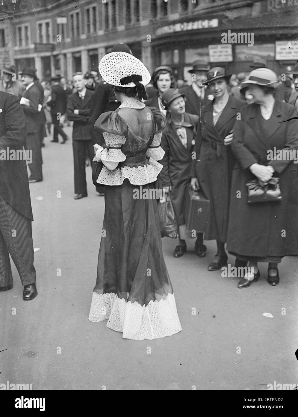 Lace and bareback for Ascot. A lace swotting up worn with a lace trimmed bareback frock by woman racegoer leaving Waterloo station for the opening day of ascot 15 June 1937 Stock Photo